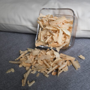 Zirbenspähne in Glasschüssel an ein Körnerkopfkissen angelehnt. Zirbenfüllung für Körnerkopfkissen.