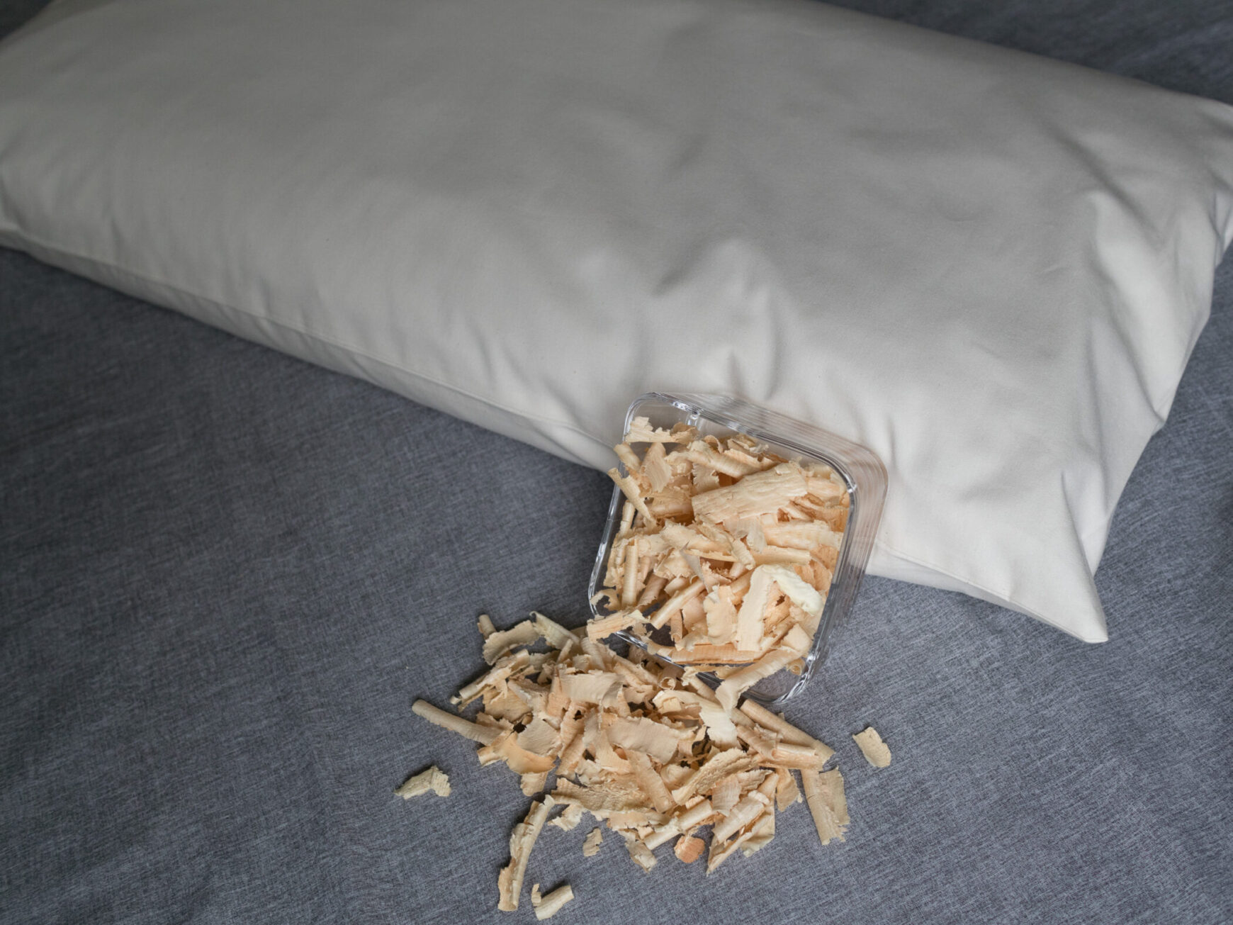 Zirbenspähne in Glasschüssel an ein Körnerkopfkissen angelehnt. Zirbenfüllung für Körnerkopfkissen.