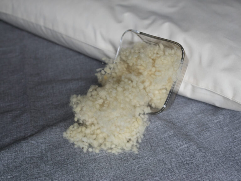 Schafswolle in Glasschüssel an ein Körnerkopfkissen angelehnt. Schafswollefüllung für Körnerkopfkissen.