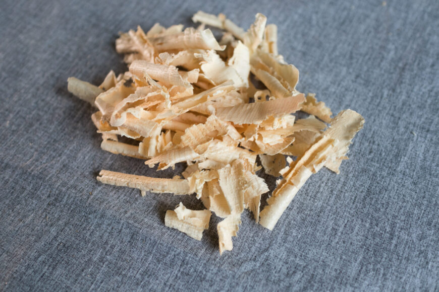 Zirbenspäne als Füllung für Körnerkissen als Nahaufnahme auf grauem Hintergrund